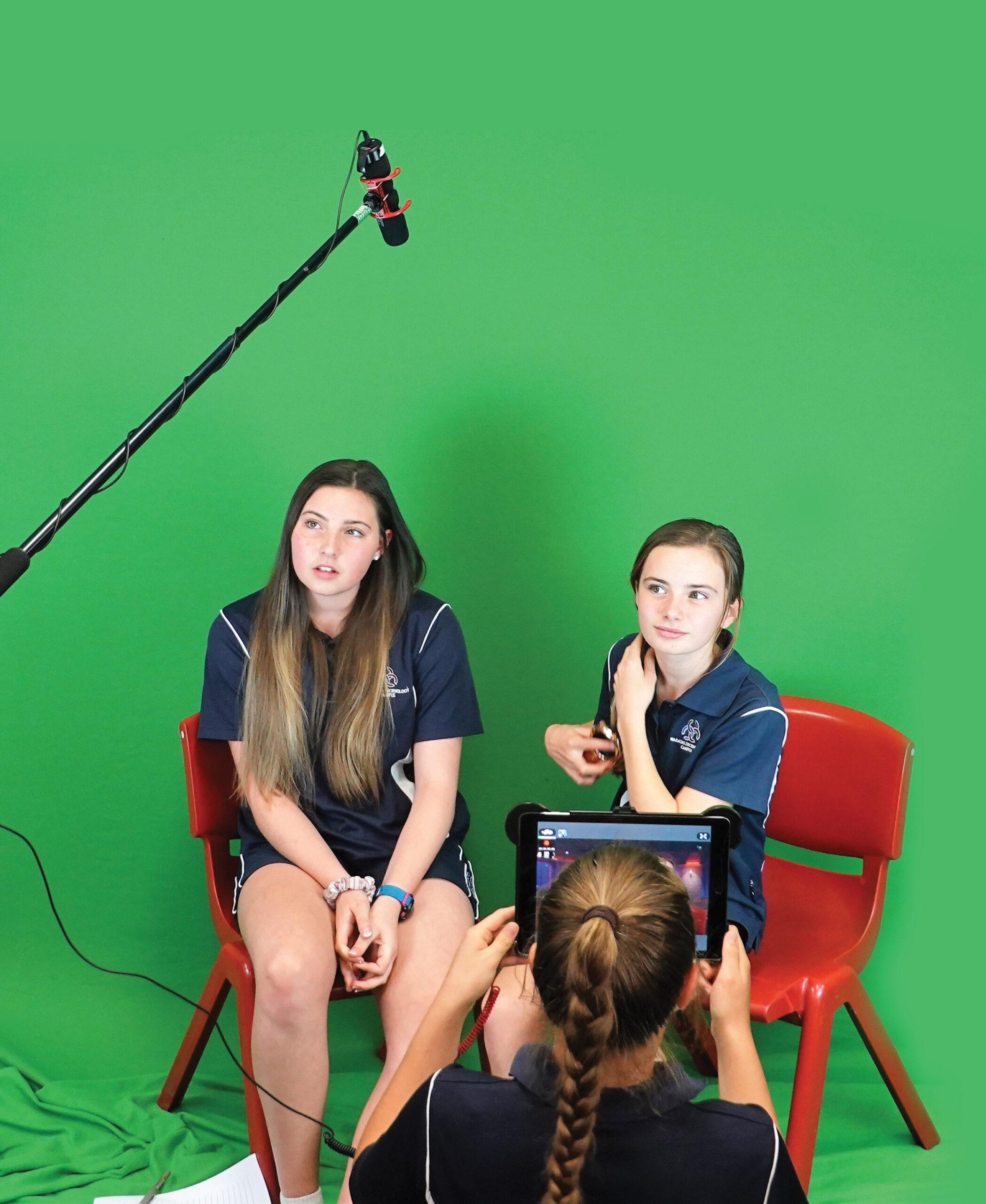 an image of two young femal adults infront of a green screen